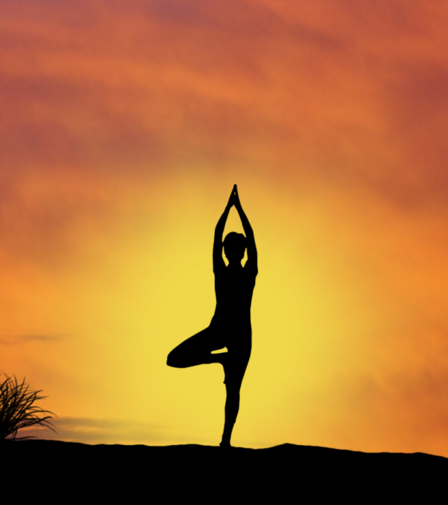 A woman gracefully practicing yoga at sunset, her silhouette beautifully captured in this serene image.